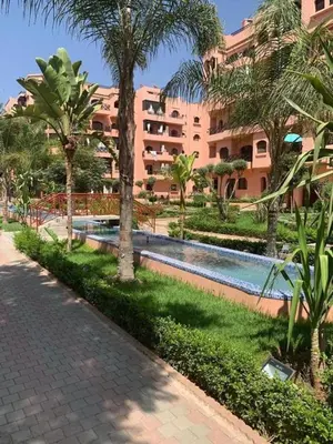 a resort with a swimming pool in front of a building at Appartement de Luxe Piscines et Jardins in Marrakech