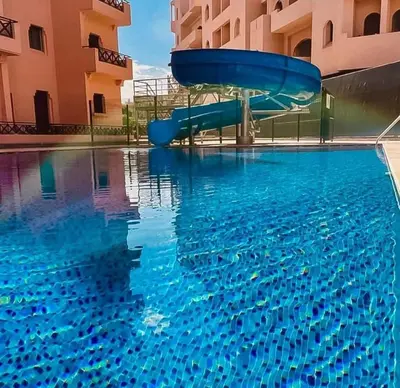a blue water slide in a swimming pool at Appartement de Luxe Piscines et Jardins in Marrakech
