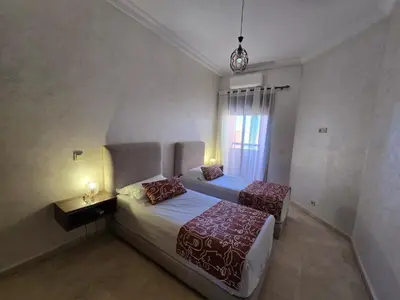 a hotel room with two beds and a window at Appartement de Luxe Piscines et Jardins in Marrakech