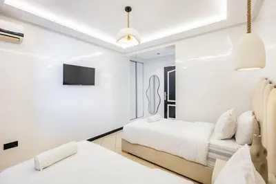 a white bedroom with two beds and a couch at Luxury Apartment In Majorelle Downtown Speed Wi-Fi and AC Calm in Marrakech
