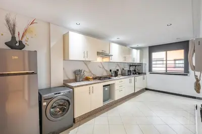 a kitchen with white cabinets and a washer and dryer at Luxury Apartment In Majorelle Downtown Speed Wi-Fi and AC Calm in Marrakech