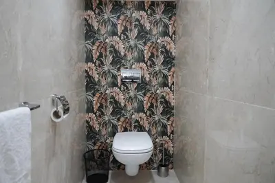 a bathroom with a toilet and a wallpaper with palm trees at Mamounia loft by M&I in Marrakech
