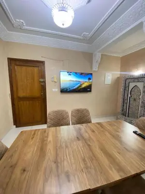 a room with a large wooden table and chairs at Apartment in Marrakech Mabrouka in Marrakech