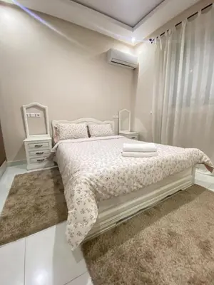 a white bedroom with a bed and a mirror at Apartment in Marrakech Mabrouka in Marrakech
