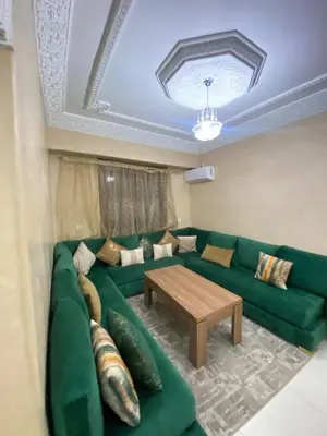 a living room with a green couch and a table at Apartment in Marrakech Mabrouka in Marrakech