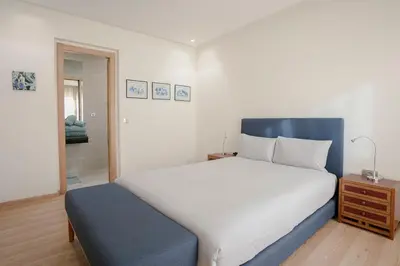a bedroom with a large bed with a blue headboard at The Maison Épure - Marrakesh - Prestigia in Marrakech