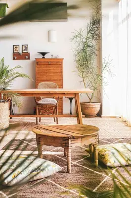 a wooden table and bench in a room with potted plants at Villa Primerose in Marrakech