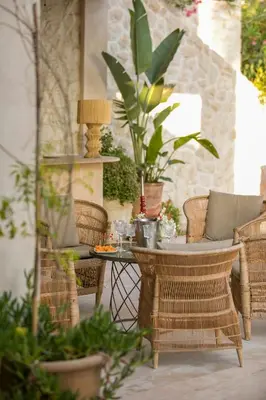 a patio with a table and chairs and plants at Villa Primerose in Marrakech