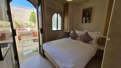 a bedroom with a white bed and a large window at Riad Casa Léa - Palais Bahia - Bassin & Pt Déj in Marrakech