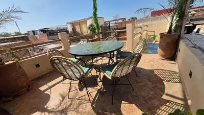 a patio with a table and chairs on a balcony at Riad Casa Léa - Palais Bahia - Bassin & Pt Déj in Marrakech