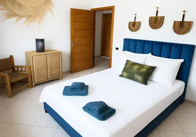 a bedroom with a bed with two blue pillows on it at Appart du centre 9 in Marrakech