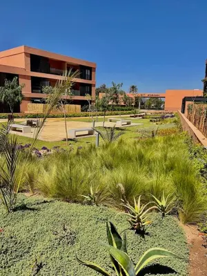 a field of plants in front of a building at Luxueux Appartement rez-de-chaussée Noria Golf in Marrakech