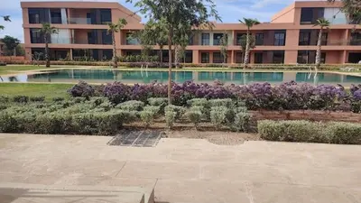 a building with a large swimming pool with purple flowers at Luxueux Appartement rez-de-chaussée Noria Golf in Marrakech