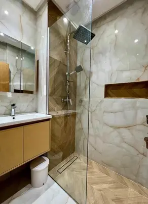 a bathroom with a shower and a toilet and a sink at Chic Urban Retreat Bright Apartment in Targa in Marrakech