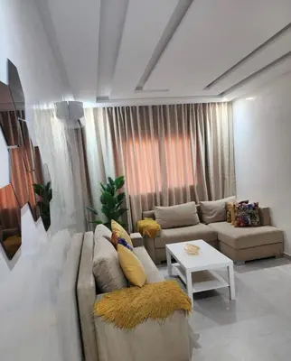 a living room with a couch and a table at Chic Urban Retreat Bright Apartment in Targa in Marrakech