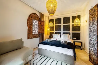 a bedroom with a bed and a couch at Riad Tigmmi - Exclusive - Pool - Free BF - 10 pax in Marrakech