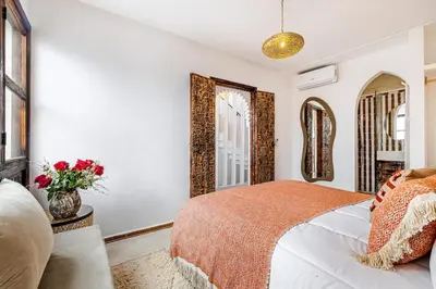 a bedroom with a bed and two mirrors at Riad Tigmmi - Exclusive - Pool - Free BF - 10 pax in Marrakech