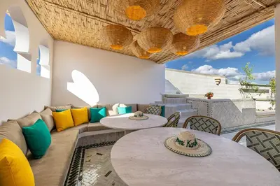 a patio with tables and chairs and a couch at Riad Tigmmi - Exclusive - Pool - Free BF - 10 pax in Marrakech