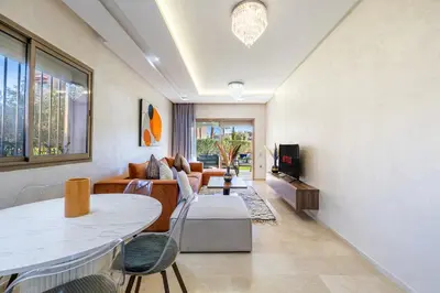a living room with a couch and a table at Familial appt-Prestigia- 2BR-Pool-Free parking in Marrakech