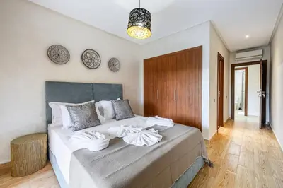 a bedroom with a bed with white towels on it at Familial appt-Prestigia- 2BR-Pool-Free parking in Marrakech