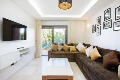 a living room with a couch and a tv at Neuf, sûr et confortable Piscine familiale 10 mn de Guéliz in Marrakech