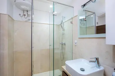 a bathroom with a glass shower and a sink at Neuf, sûr et confortable Piscine familiale 10 mn de Guéliz in Marrakech
