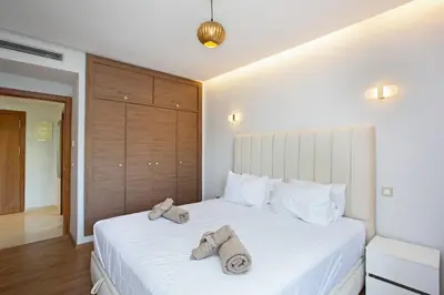 a bedroom with a large white bed with towels on it at Neuf, sûr et confortable Piscine familiale 10 mn de Guéliz in Marrakech