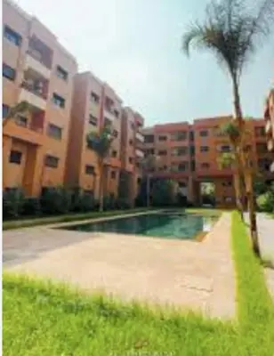 a swimming pool in front of a building with a palm tree at Modern Oasis in Heart of Guéliz Pool Balcony in Marrakech