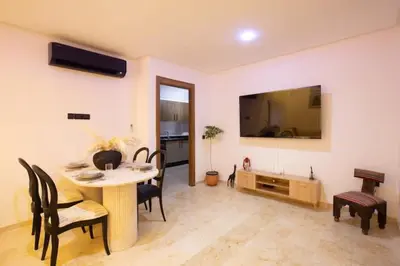 a living room with a table and chairs and a television at Modern Oasis in Heart of Guéliz Pool Balcony in Marrakech