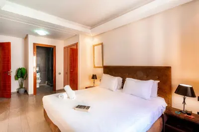 a bedroom with a large white bed with a book on it at Menara gardens in Marrakech