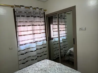 a bedroom with a bed and a mirror and a window at Marrakech in Marrakech