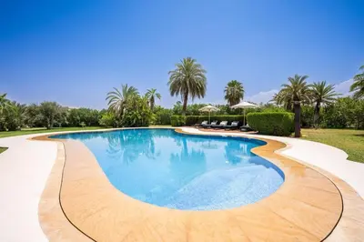 a swimming pool in a yard with palm trees at MIKESTAY Domaine ATIKA in Segraga