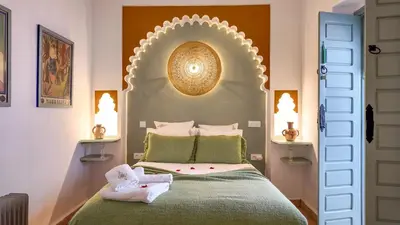 a bedroom with a bed with a large headboard at Riad Tamazy in Marrakech