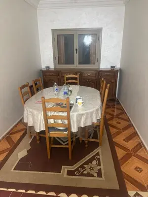 a dining room with a table and chairs and a window at Yassine in Marrakech
