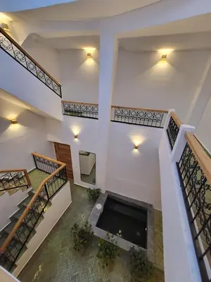 a large white building with stairs and a fireplace at Riad in Marrakech