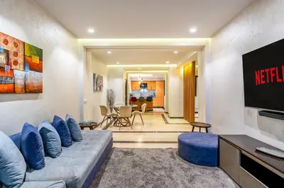 a living room with a couch and a tv at Bright & Airy Modern Flat in heart of Marrakech in Marrakech