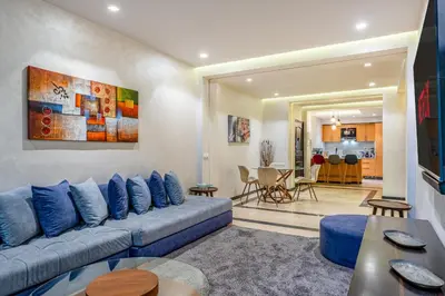 a living room with a blue couch and a table at Bright & Airy Modern Flat in heart of Marrakech in Marrakech