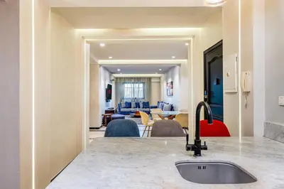 a kitchen with a sink and a living room at Bright & Airy Modern Flat in heart of Marrakech in Marrakech
