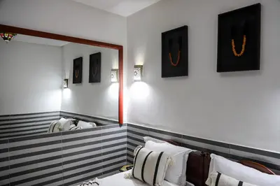a bathroom with a mirror and a bed with pillows at Riad Allal in Marrakech