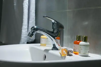 a bathroom sink with a faucet and two bottles at Riad Allal in Marrakech