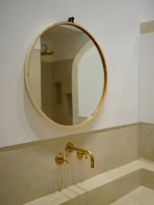 a bathroom sink with a gold faucet and a mirror at Riad privatif Les Tamaris in Marrakech