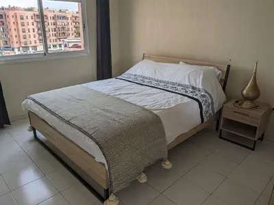 a bed in a bedroom with a window and a table at Rooftop apartment with large terrace in Guéliz in Marrakech