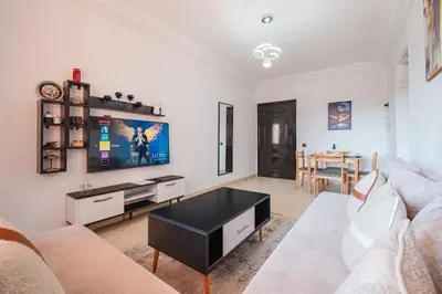 a living room with a couch and a tv at Appartement 2 chambres avec terrasse ensoleillée in Marrakech