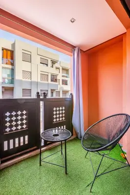 a balcony with a table and two chairs at superbe appartement au coeur de guiliz - victor Hugo in Marrakech