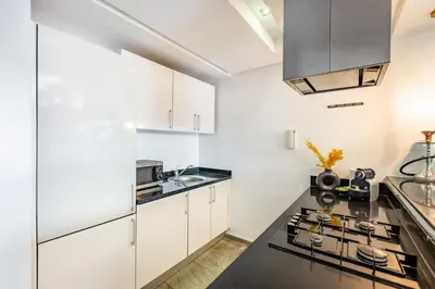 a kitchen with white cabinets and a black counter top at superbe appartement au coeur de guiliz - victor Hugo in Marrakech