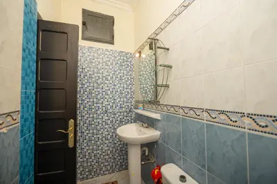a bathroom with a sink and a toilet and a mirror at Riad Blue Marrakech 4 Rooms Jacuzzi Terrace and Pool in Marrakech
