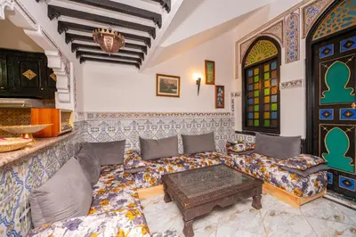 a living room with a couch and a table at Riad Blue Marrakech 4 Rooms Jacuzzi Terrace and Pool in Marrakech
