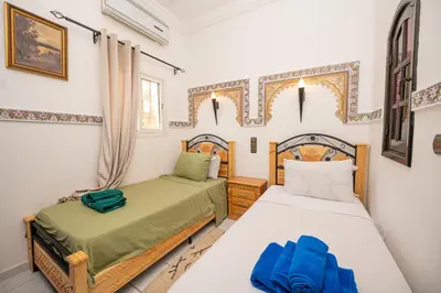 a bedroom with two beds and a window at Riad Blue Marrakech 4 Rooms Jacuzzi Terrace and Pool in Marrakech