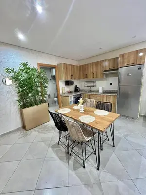 a large kitchen with a wooden table and chairs at New! Apartment F2 Gueliz Station Balcony renovated in Marrakech