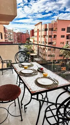 a table with plates on it on a balcony at Appartement Haut Standing 2 Chambres avec 2 Terrasses au Centre Gueliz Marrakech in Marrakech